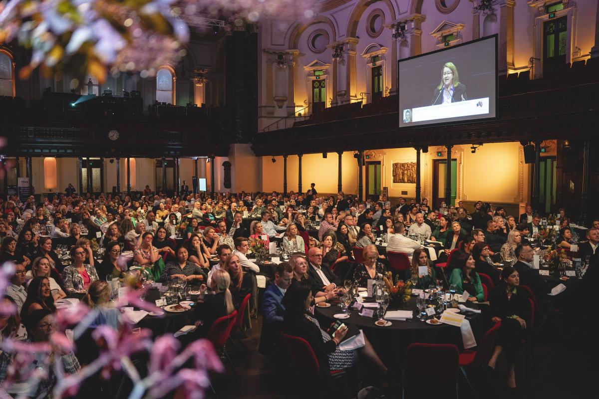 Wide shot of the full room with people sitting.