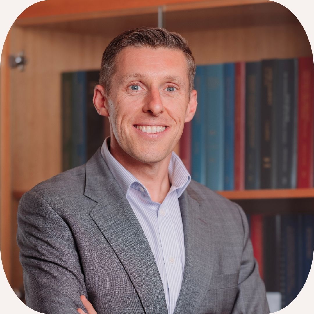 Headshot of Craig Mutton who has short, light hair and wears a grey suit.