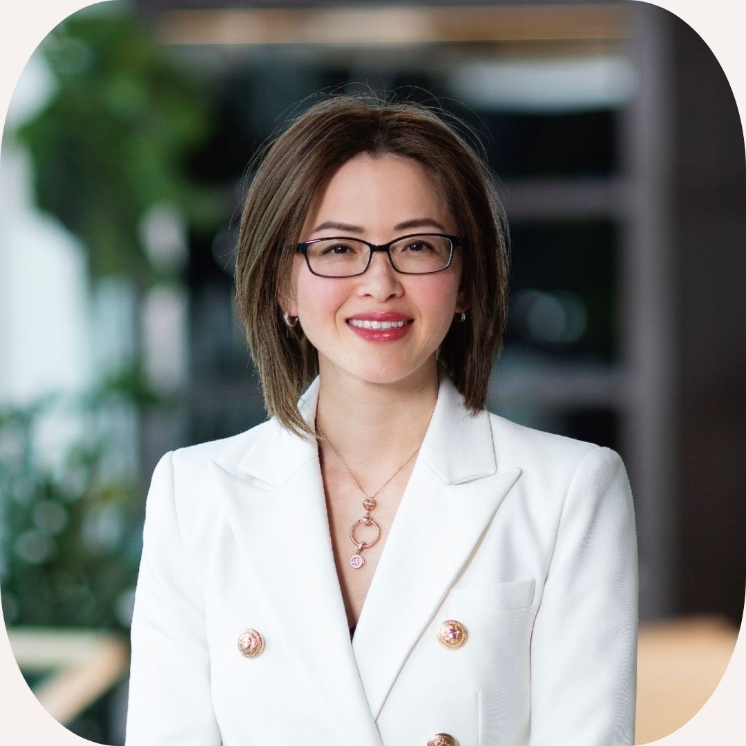 Headshot of Tara Le Friedman who wears a white jacket, a necklace, glasses and has a brown bob haircut.