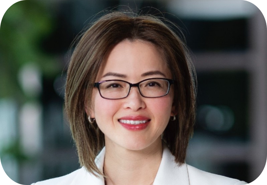 Headshot of Tara Le Friedman who wears a white jacket, a necklace, glasses and has a brown bob haircut.