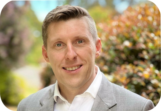 Headshot of Craig Mutton, a white man with light hair, a purple shirt and grey jacket.