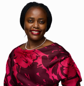 Image of a woman with dark hair in a red patterned top smiling at the camera
