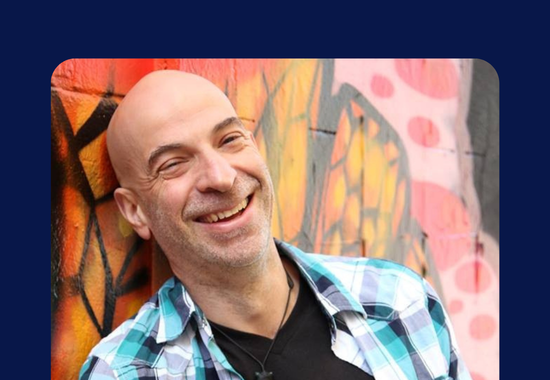 Gregory smiling against a graffiti wall