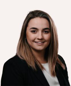 Headshot of Dr Jennifer Chelsea Veres wearing a black blazer and white top against a light background.